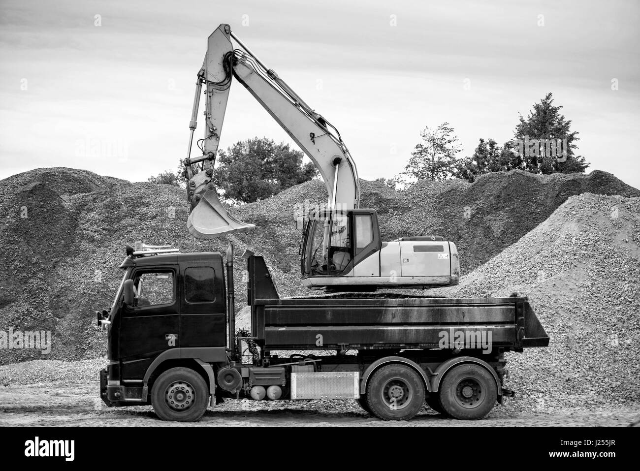 Riga, Lettland - 25. September 2016: Der Hafen von Riga. Bagger und LKW steht auf der Baustelle an der Kies-Haufen. Stockfoto