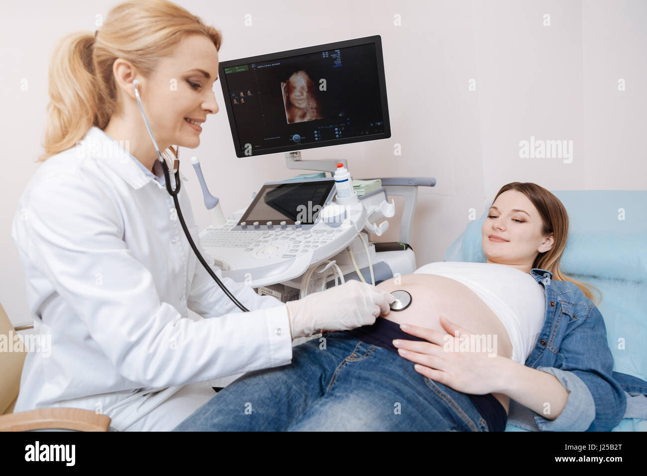 Lebendige Geburtshelfer mit Stethoskop Check-up im Krankenhaus Stockfoto
