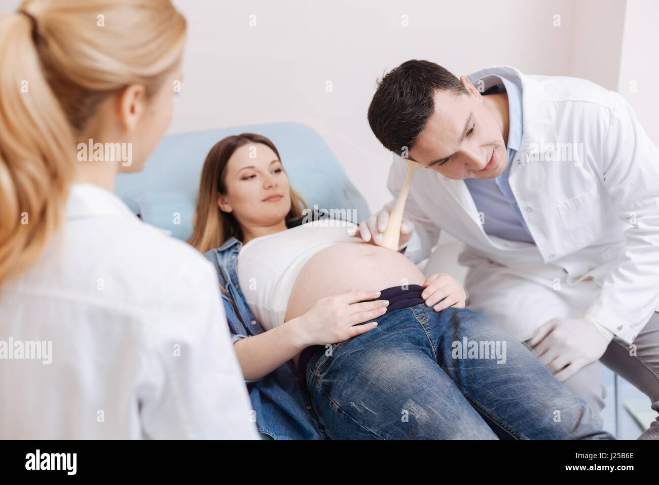Konzentriert Geburtshelfer bieten schwangeren Bauch Untersuchung in der Klinik Stockfoto