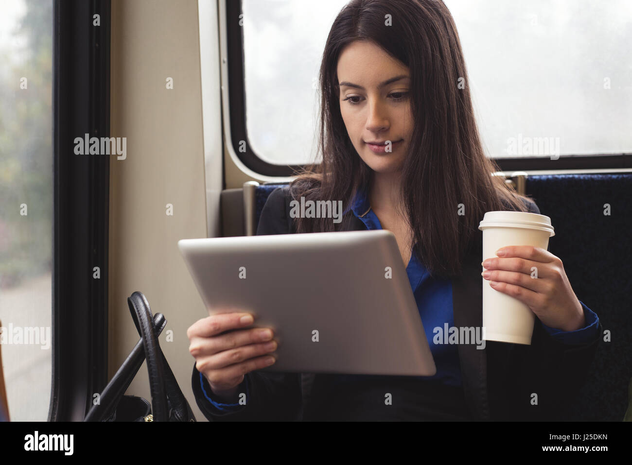 Frau mit Tablet-PC beim Sitzen im Zug Stockfoto
