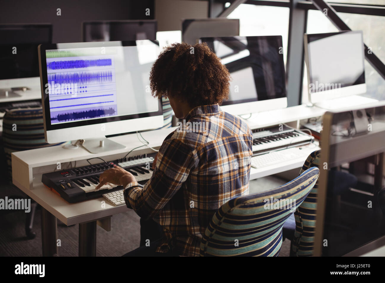 Männliche Tontechniker arbeiten an digitalen Bearbeitungsbildschirm im Tonstudio Stockfoto