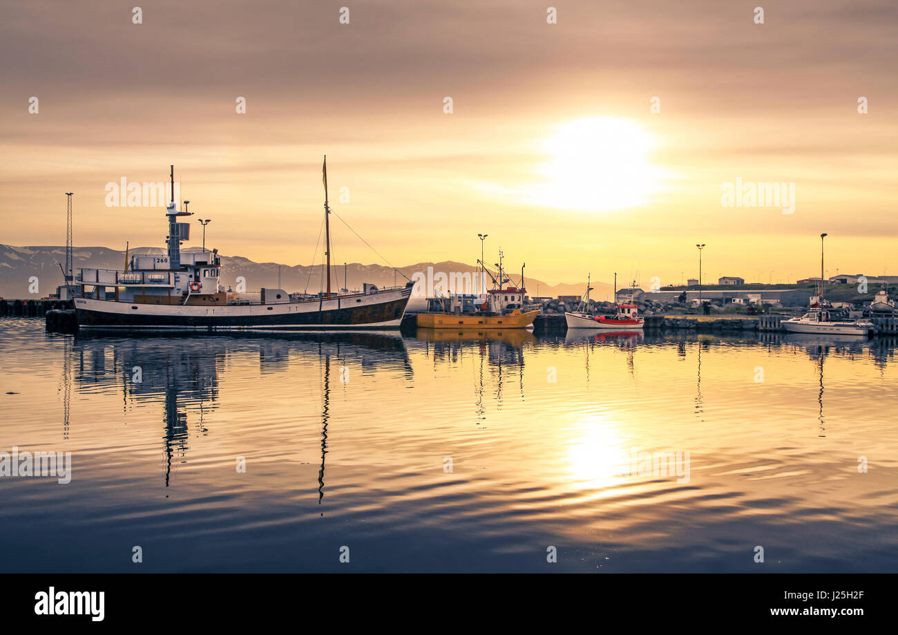 Schiffe liegen im Hafen Husavik bei Sonnenuntergang, Island Stockfoto