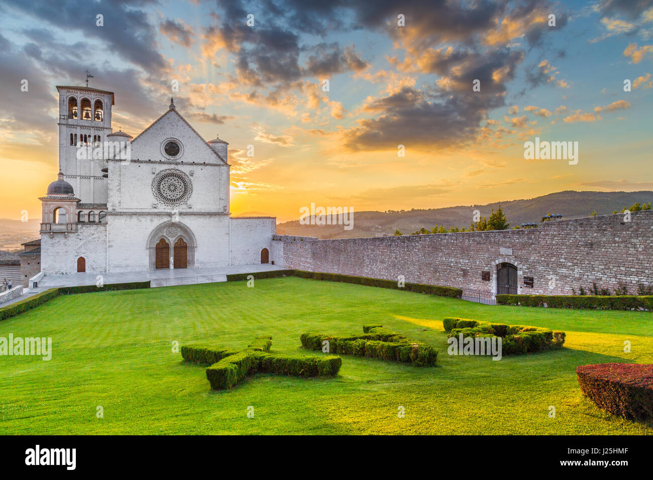 Berühmte Basilika des Heiligen Franziskus von Assisi (Basilica Papale di San Francesco) mit Pax melden Sie sich an schönen goldenen Abendlicht bei Sonnenuntergang, Umbrien, Italien Stockfoto