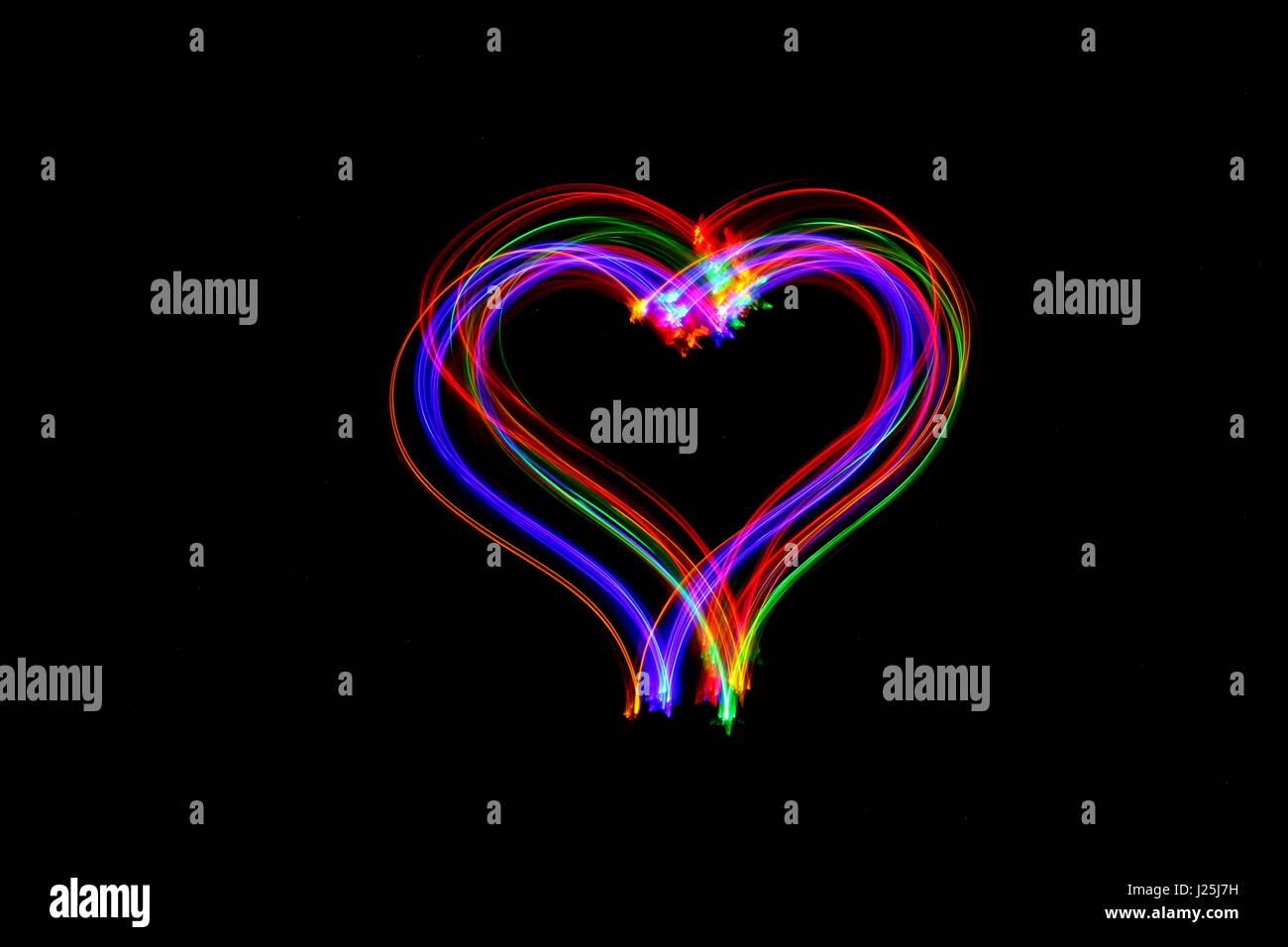 Lange Belichtung Foto von Neon multi-color in einem Herzen Umriss der Form vor einem schwarzen Hintergrund. Licht Malerei Fotografie, abstrakte Farbe Stockfoto