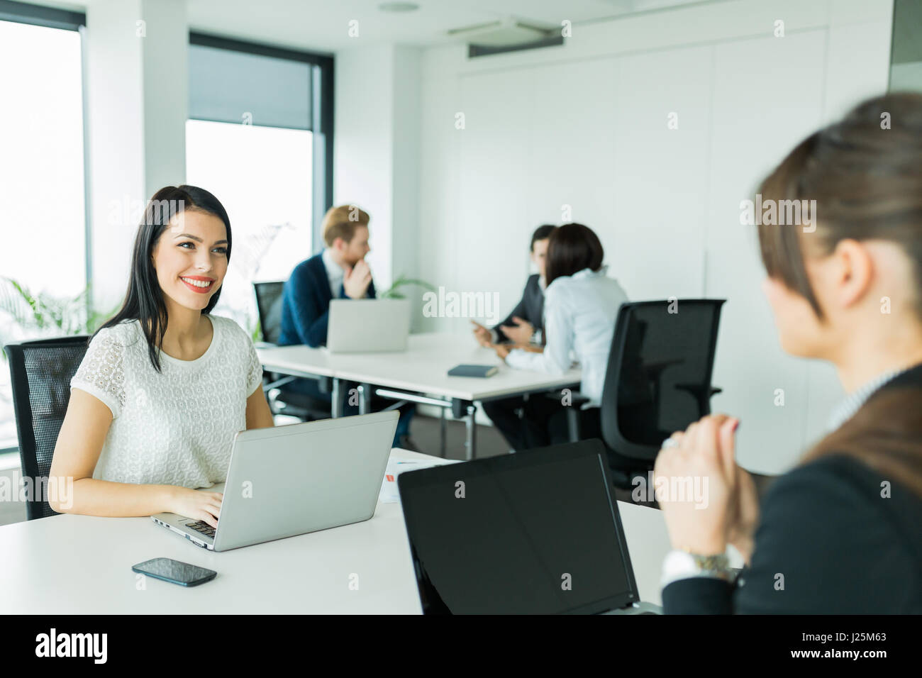 Geschäftsfrauen, die Austausch von Gedanken in ein schönes Büro-Umgebung während der Arbeit an einem laptop Stockfoto