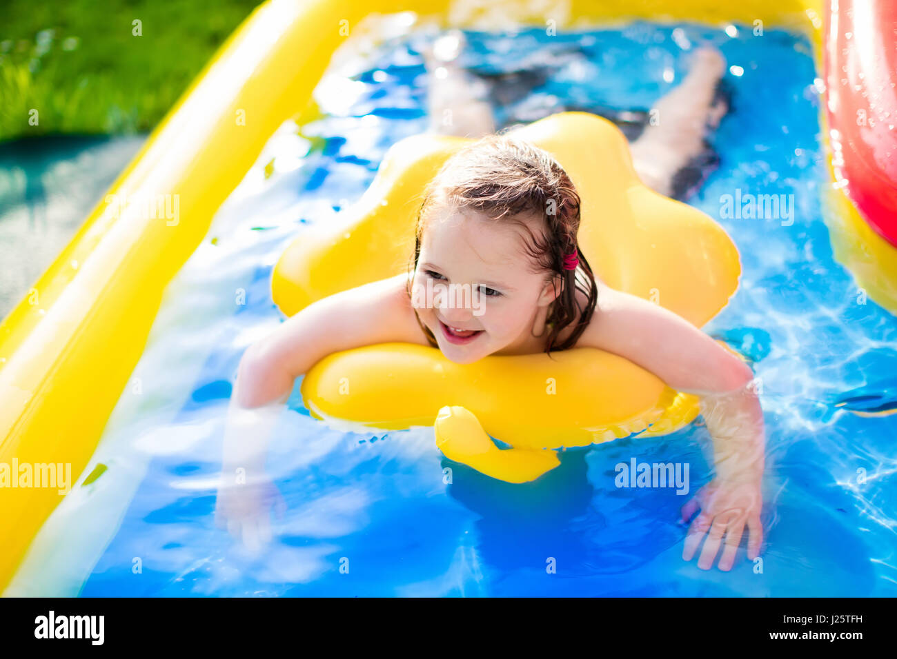 Kinder spielen im aufblasbaren Babybecken. Kinder schwimmen und