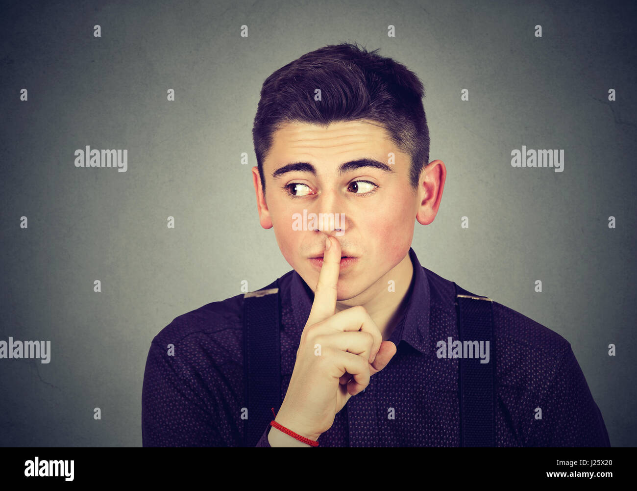 Mann mit Finger auf Lippen Geste isolierten auf grauen Hintergrund Stockfoto