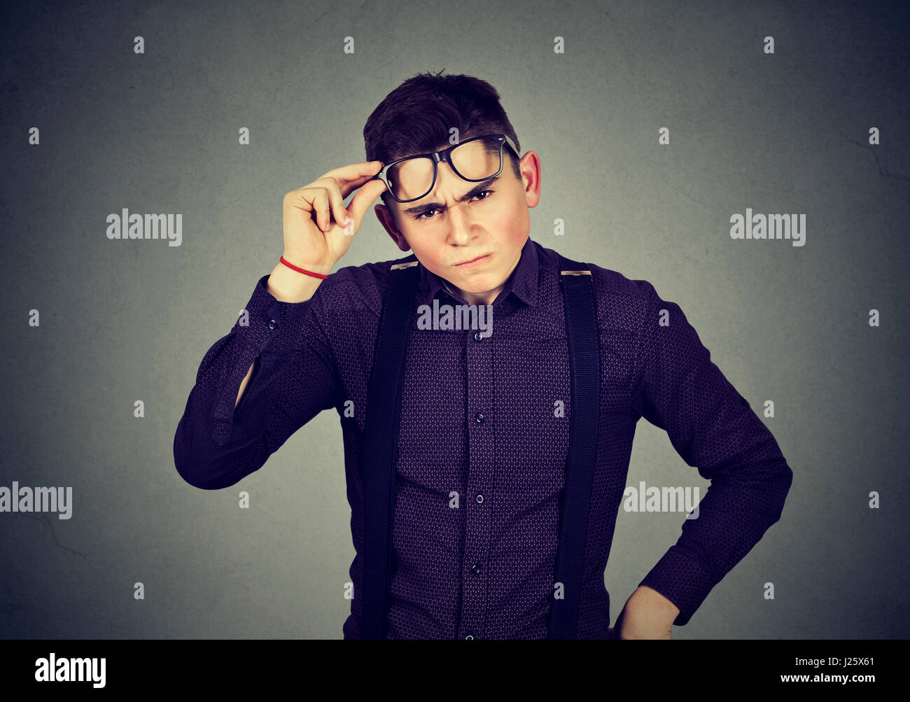 Lustig aussehender skeptisch mürrischer junger Mann in Gläsern Stockfoto