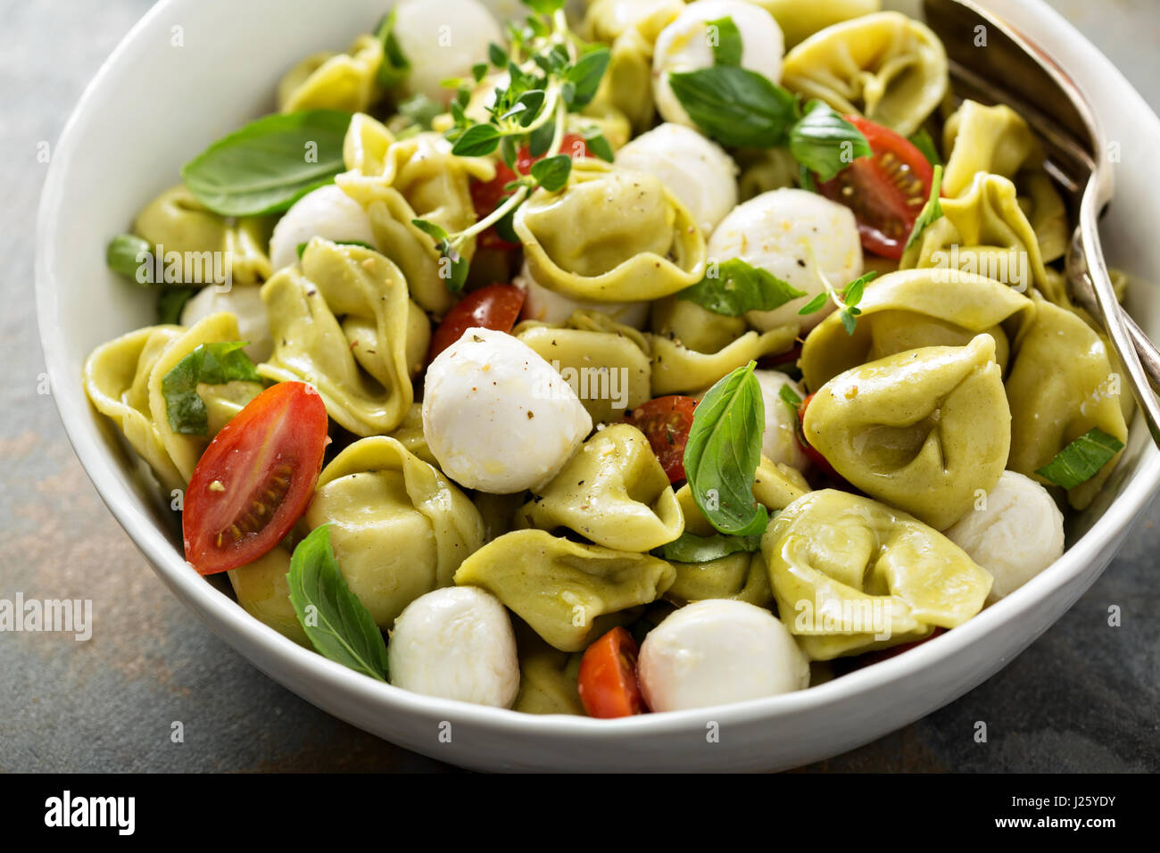 Italienische Pasta-Salat mit Spinat-Ricotta-Tortellini, Mozzarella, Tomaten  und Basilikum Stockfotografie - Alamy