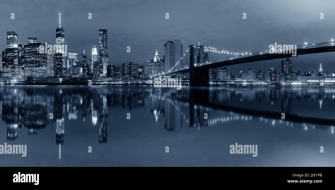 Manhattan Downtown Stadtblick mit Brooklynbridge bei Nacht mit Reflexionen im BW Stockfoto