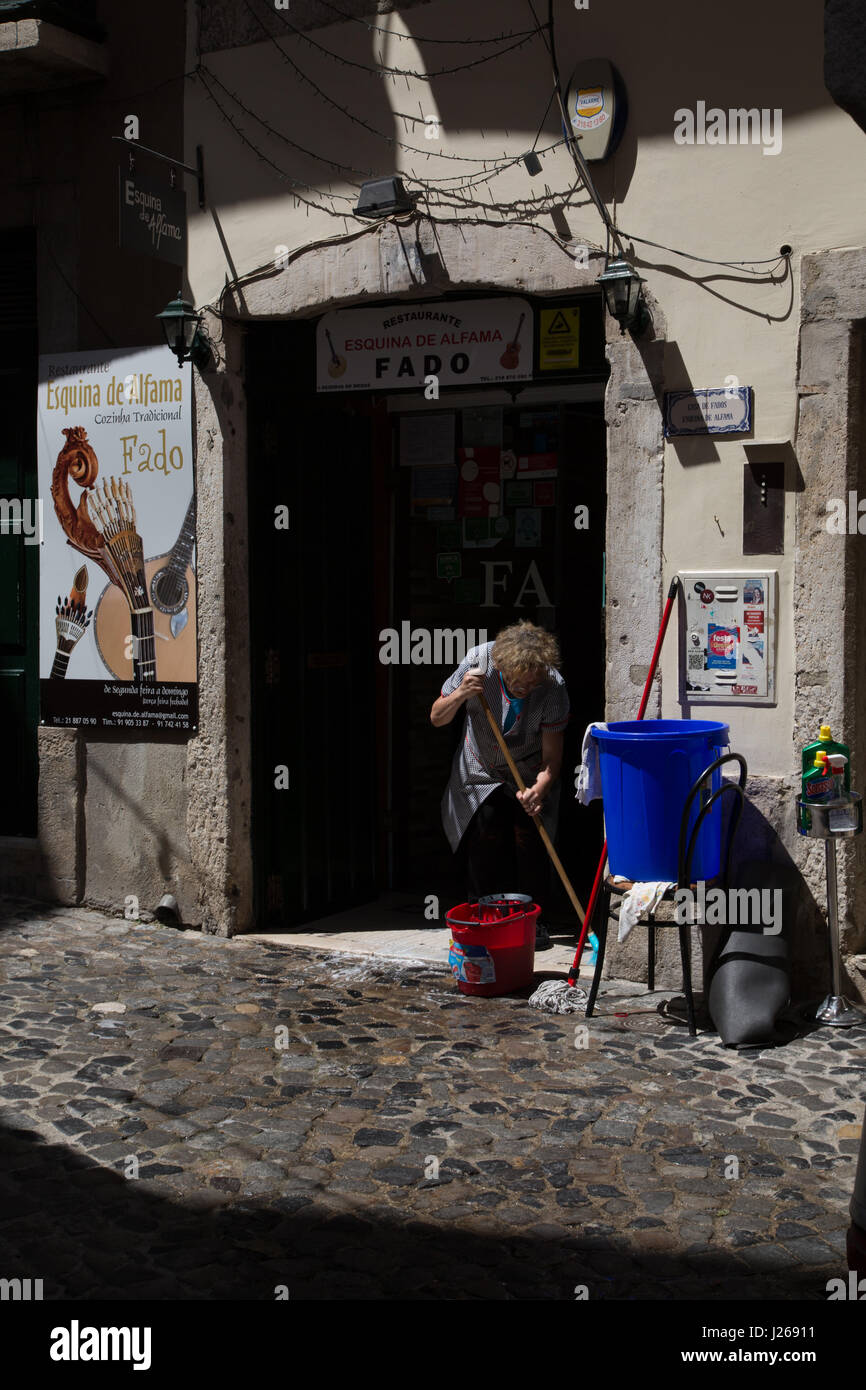 Eine Dame Reinigung gewissermaßen Tür in Lissabon, Portugal. Stockfoto