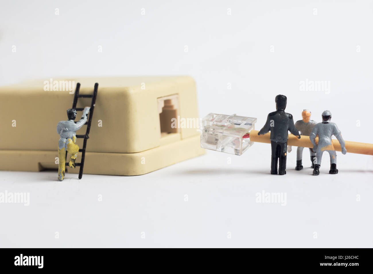 Der Miniatur-Mann einstecken Kabel Telefonanschluss, Nahaufnahme Schuss Stockfoto