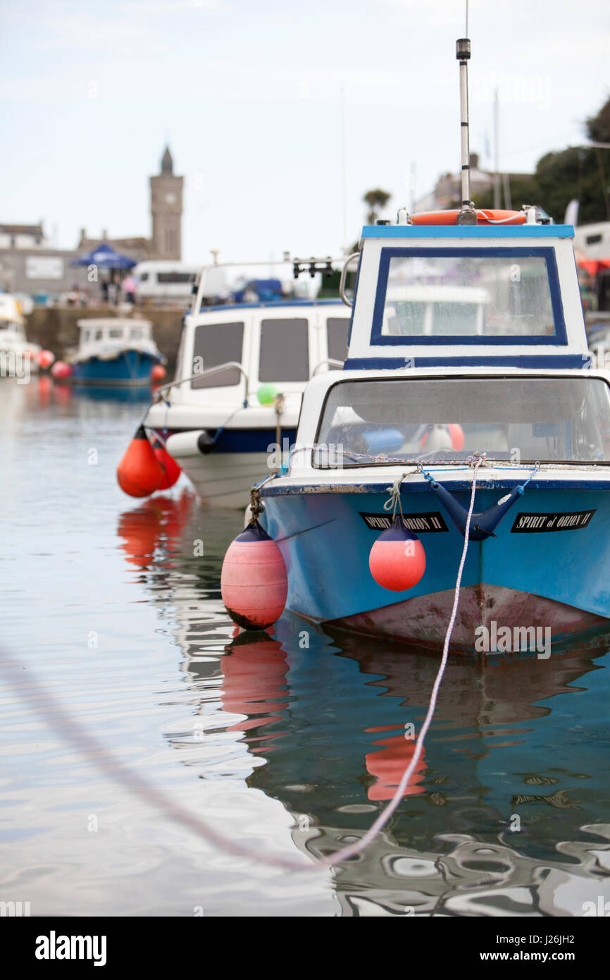 Angelboote/Fischerboote im Hafen von Porthleven, Cornwall, UK mit dem Turm des Instituts in den Hintergrund. Stockfoto