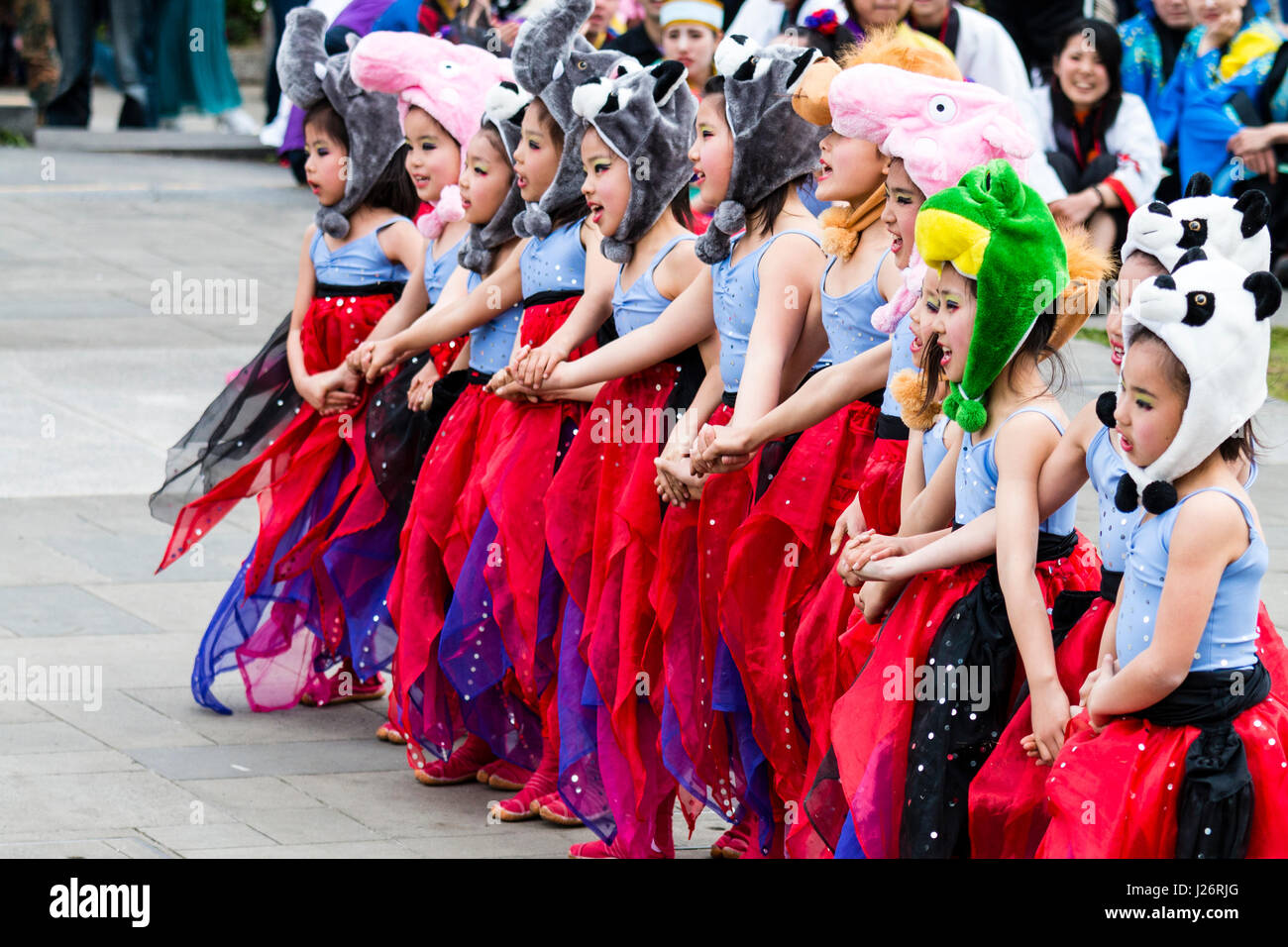 Japan, Kumamoto, Hinokuni Yosakoi Festival. Kinder Girl's Dance Team, verkleidet als Feen in Rot zogen die Kostüme mit tierischen Hüte. Tanz im Freien. Stockfoto