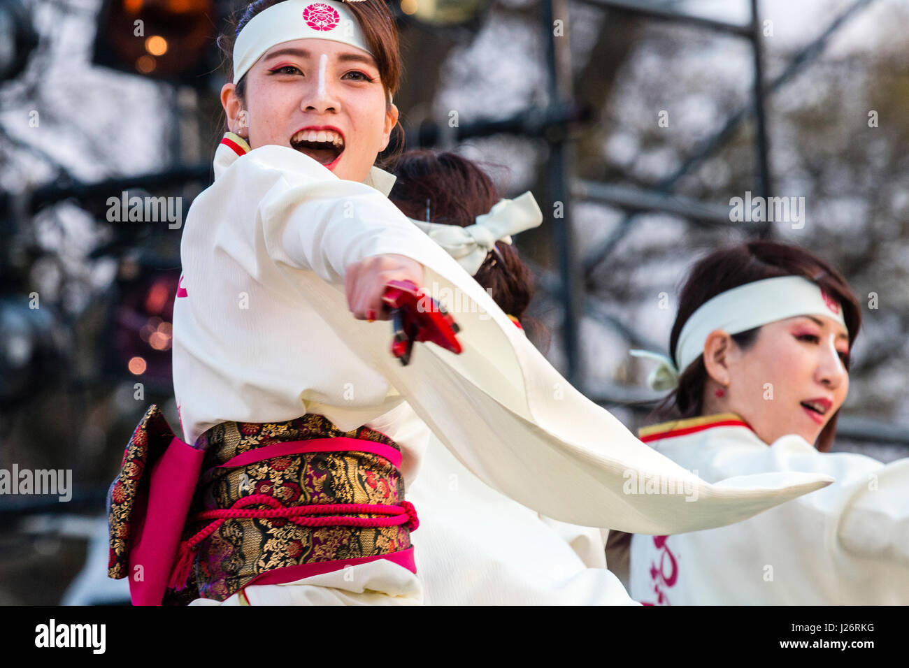 Hinokuni Yosakoi Dance Festival in Kumamoto. Japanische Frauen tanzen auf der Bühne. Tragen weiße Yukata mit roten Schärpe, und halten naruko, Klöppel. Stockfoto