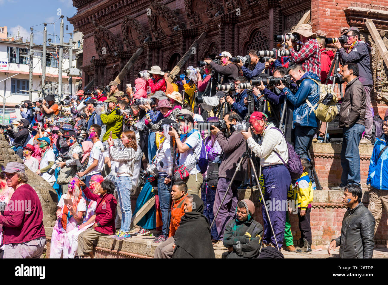 Chinesische Touristen fotografieren von Tausenden von Jugendlichen, verschmierte und Spielen mit Farbe, feiert das Holi Festival Stockfoto