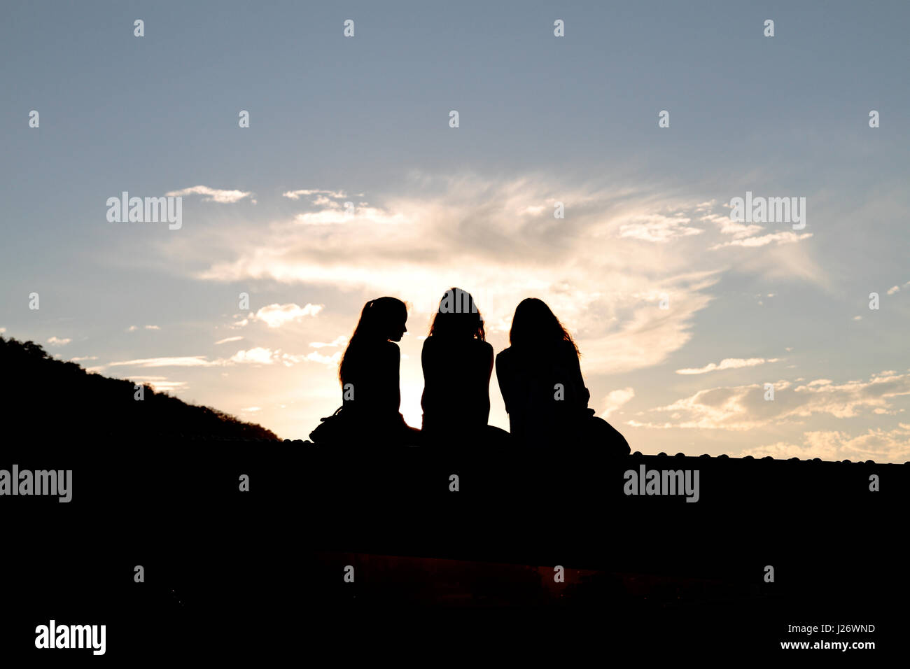 Silhouette von drei jungen Frauen gegen einen hellen blauen Sommerhimmel in Budapest, Ungarn. Stockfoto