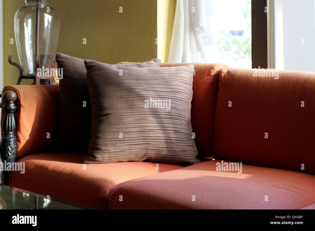 braune Kissen auf roten Sofa im Wohnzimmer Stockfotografie - Alamy