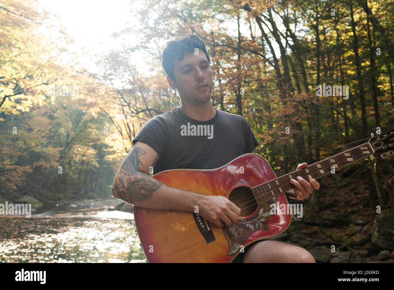 Porträt von ein hübscher junger Mann spielt akustische Gitarre Stockfoto