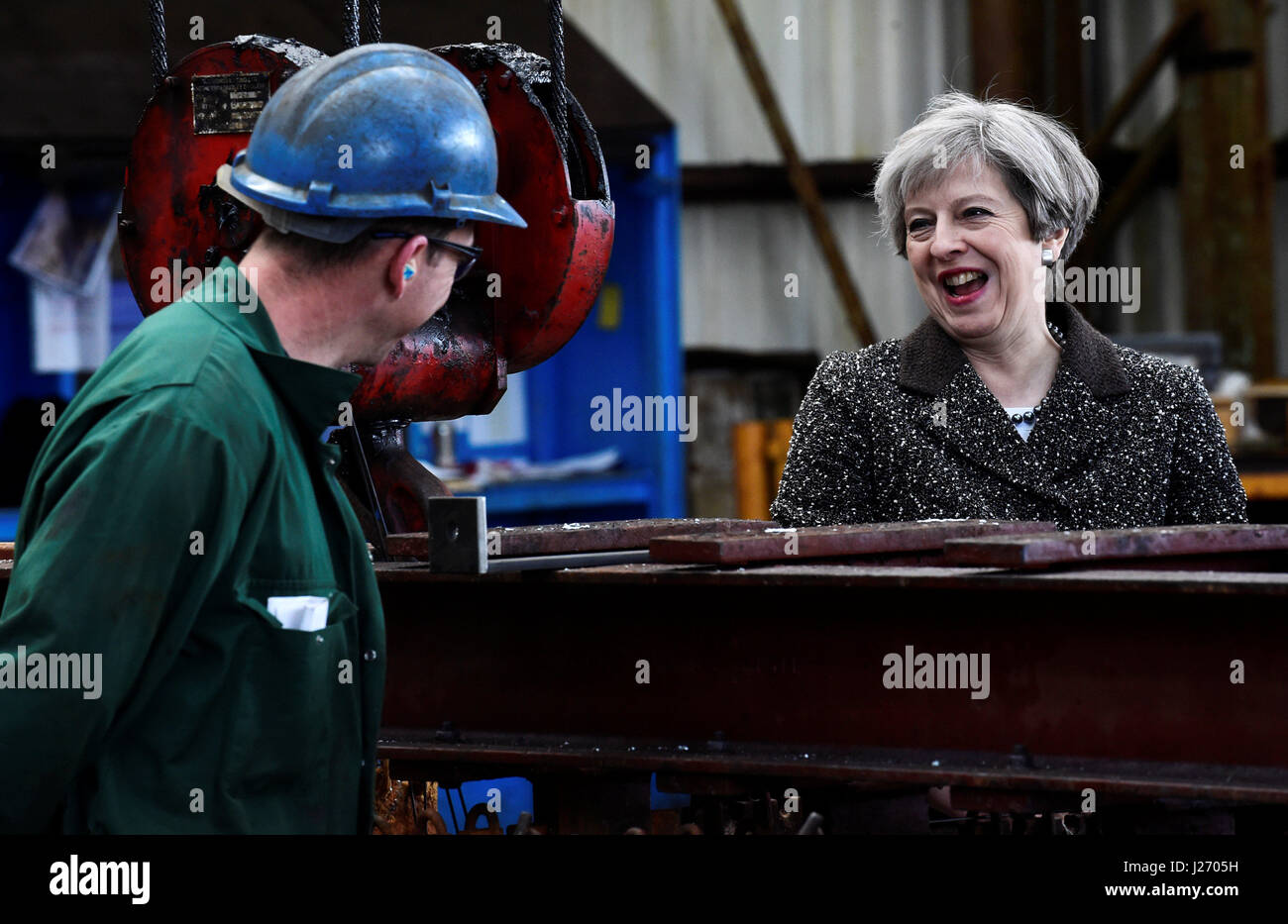 Premierminister Theresa May spricht für einen Arbeitnehmer während eines Besuchs in einem Stahlwerk in Newport, Wales. Stockfoto