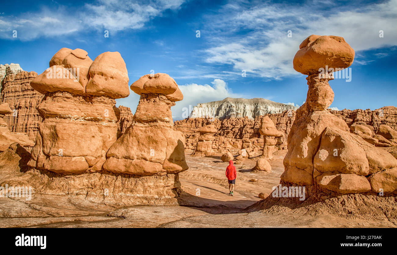 Panoramablick über männliche Person wandern inmitten atemberaubender Hoodoos Sandstein-Formationen im berühmten Goblin Valley State Park in Sommer, Utah, USA Stockfoto