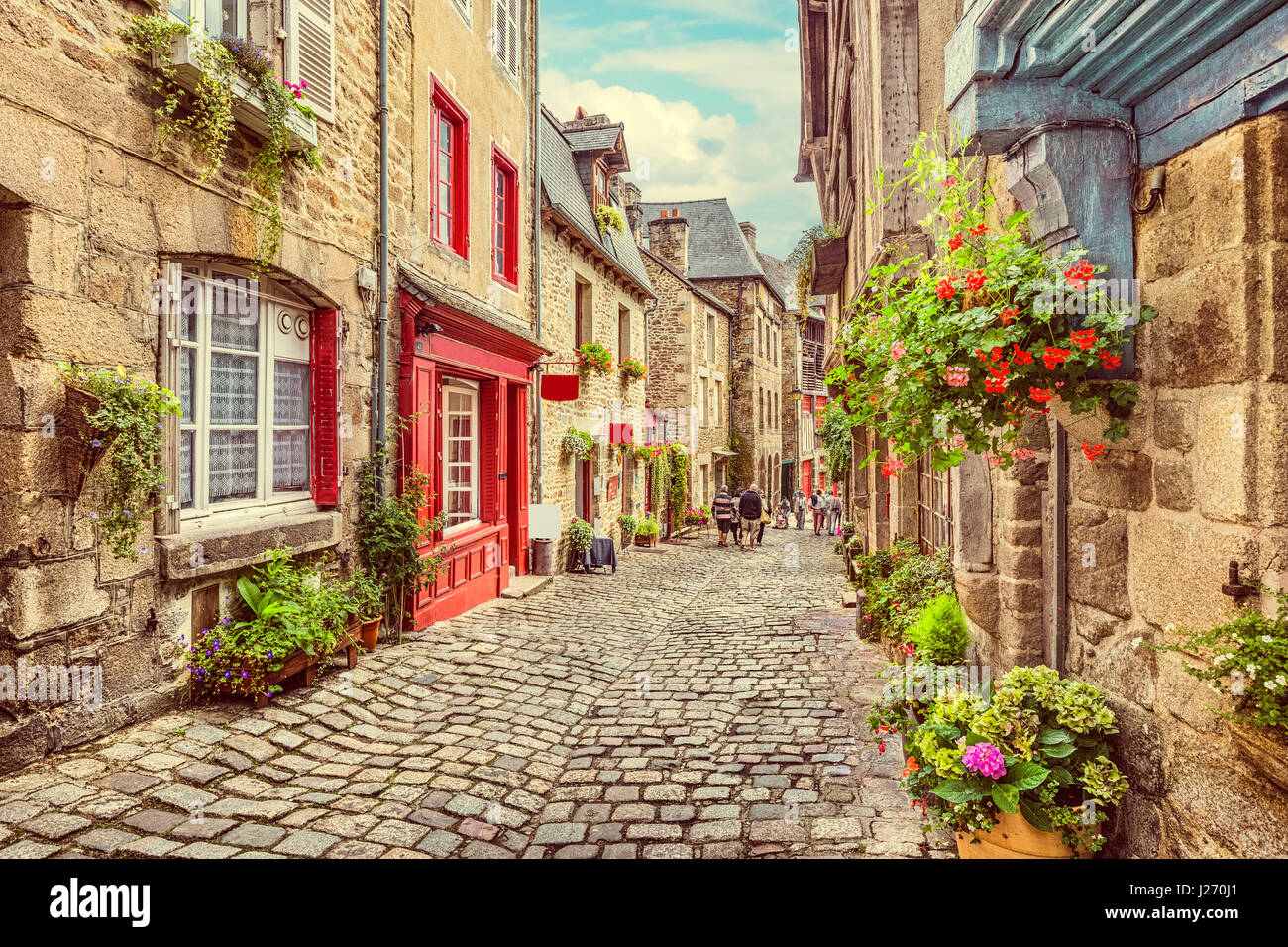 Schöne Aussicht auf die malerische enge Gasse mit historischen, traditionellen Häusern und gepflasterten Straße in eine alte Stadt in Europa mit blauem Himmel und Wolken im Sommer Stockfoto