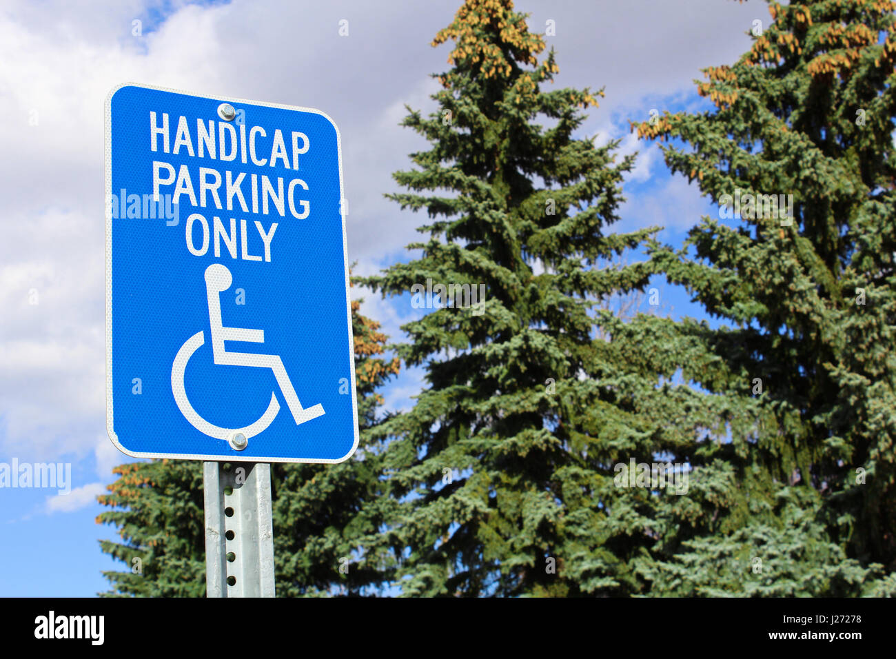 Handicap Parkplatz Schild mit Bäumen im Hintergrund. Stockfoto