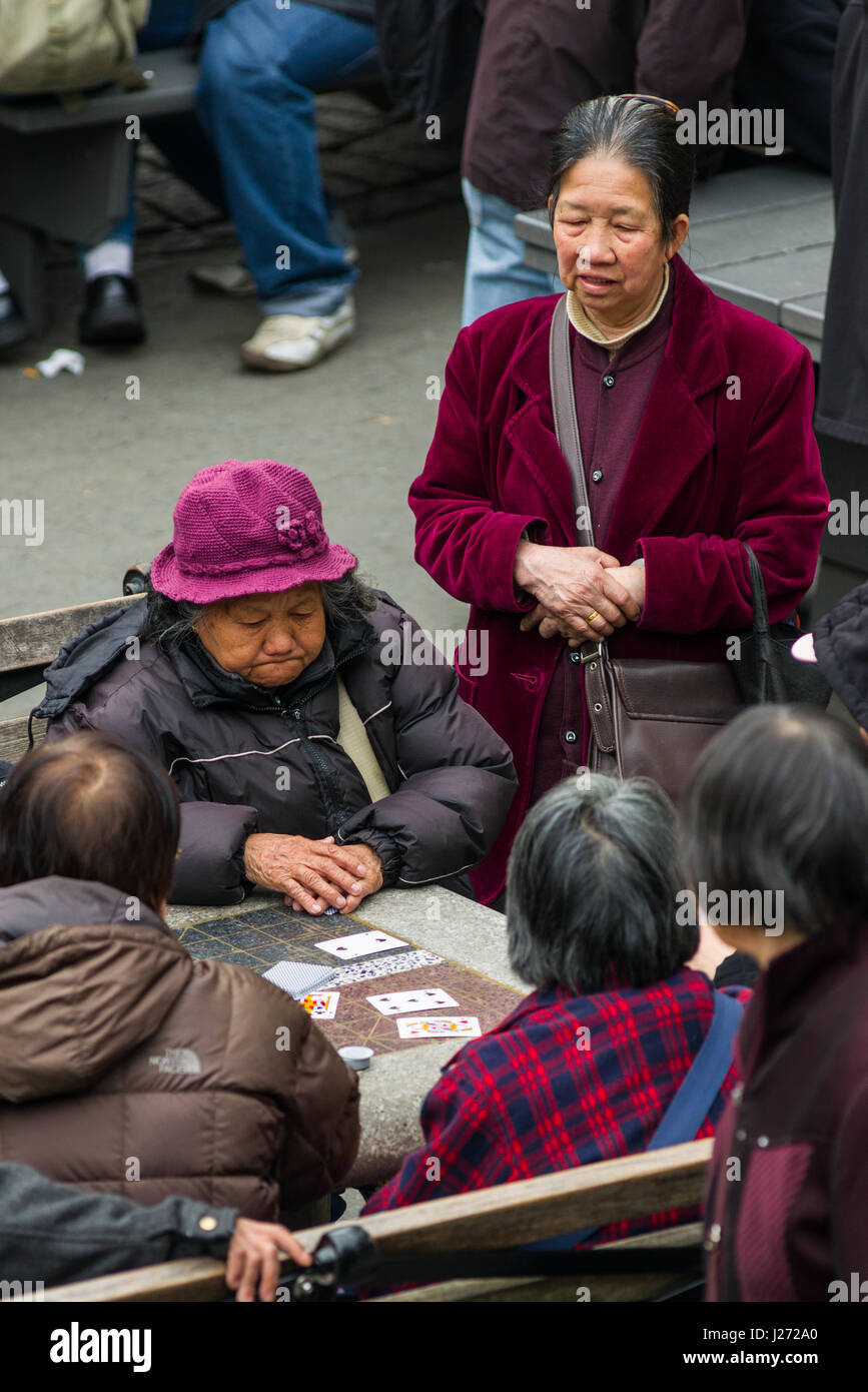 Ältere Damen spielen Kartenspiel auf einen Tisch aus Stein, Columbus Park, New York Stockfoto