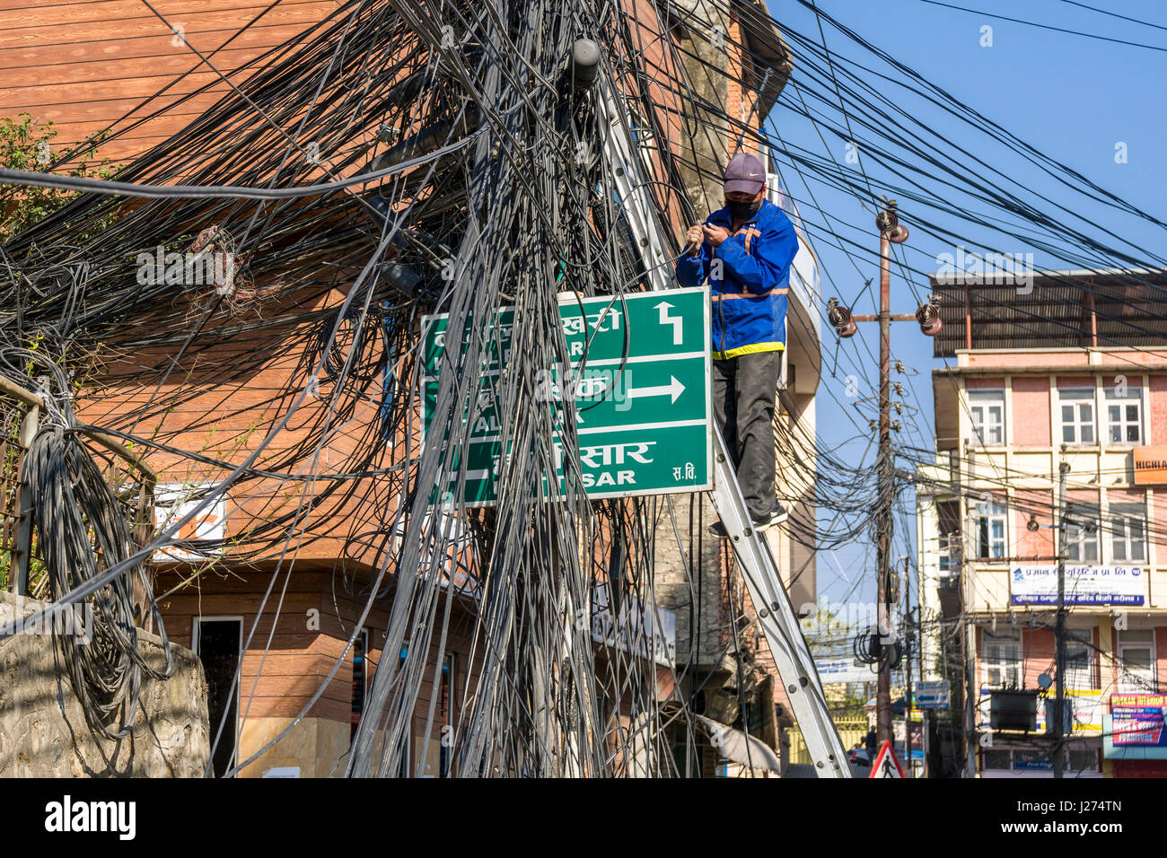 Chaotische Kabel der Stromversorgung, ein Elektriker daran arbeitet Stockfoto