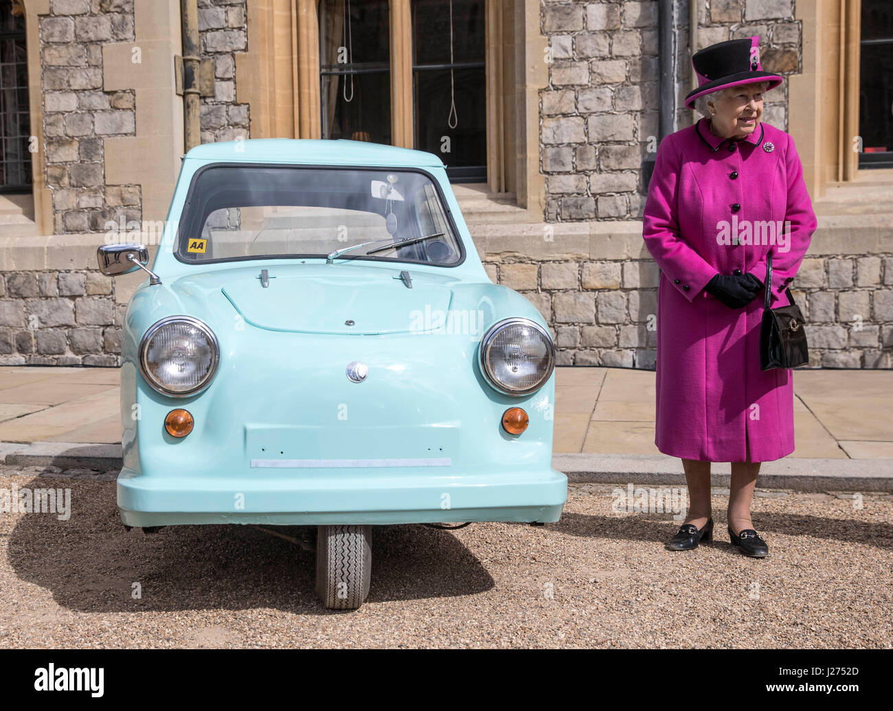 Königin Elizabeth II steht neben einem klassischen Invacar ungültig Wagen während einer Zeremonie im Windsor Castle zu feiern zum 40. Jahrestag der Motability. Die Fahrzeuge, bekannt als blaue Trikes in den 1960er und 70er Jahren wurden zur Verfügung gestellt als subventionierte, kostengünstige Fahrzeug für die Mobilität der Menschen zu helfen, die waren gebrechlich oder Behinderungen. Stockfoto