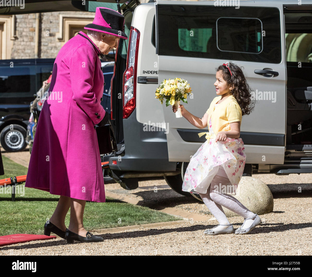 Sieben Jahre alten Dina Rayburn präsentiert Königin Elizabeth II mit Blumen während einer Zeremonie im Windsor Castle zu feiern zum 40. Jahrestag der Motability. Stockfoto