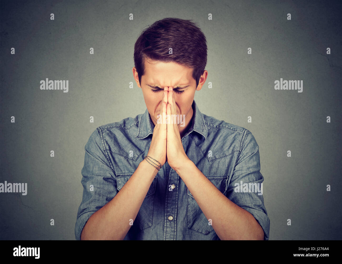 Porträt des jungen verzweifelten Menschen beten Stockfoto