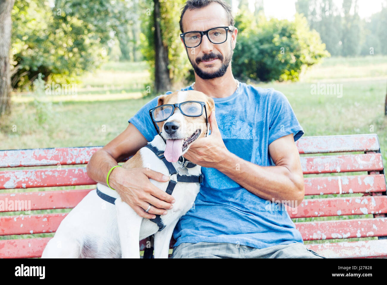 kurzsichtige Menschen mit seinem Hund das Tragen einer Brille sitzen auf einer Bank Stockfoto