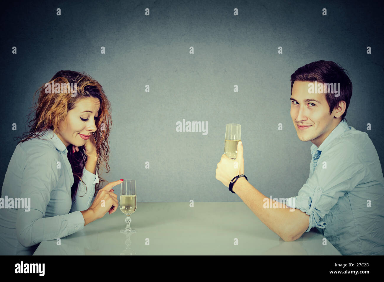 Schlauer Mann und skeptisch Frau am Tisch trinken Wein Stockfoto