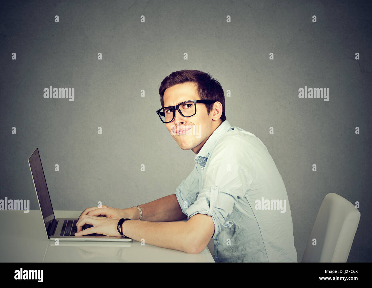 Nerdy Mann mit einem Laptopcomputer Stockfoto