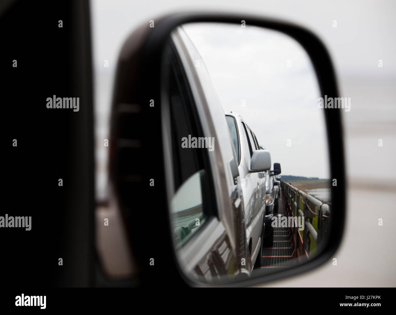 Autos können in einem Rückansicht Spiegel transportiert durch ein Motorrail Züge (DB Sylt Shuttle) zwischen der Nordsee Insel Sylt und Klanxuell, Deutschland, 20. April 2017 gesehen werden. Foto: Christian Charisius/dpa Stockfoto