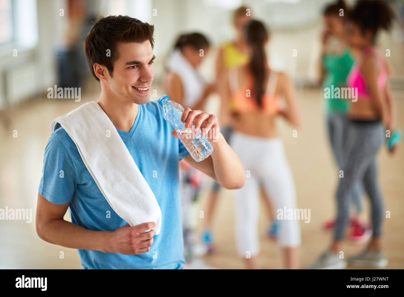 Durstige Kerl Trinkwasser aus der Flasche nach dem Training im Fitness-Studio Stockfoto