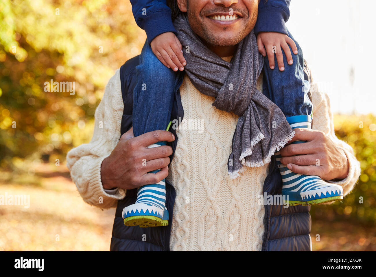 Detail des Herbst-Spaziergang mit Vater Sohn auf den Schultern tragen Stockfoto