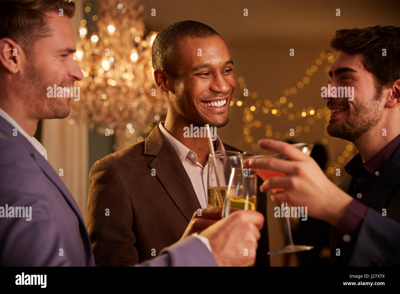 Männliche Freunden Toast zu machen, wie sie auf Party zusammen feiern Stockfoto
