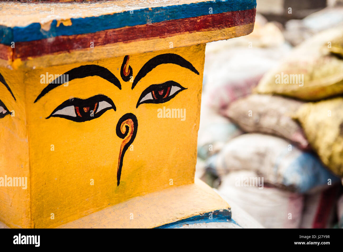Buddhas Augen, auch bekannt als Weisheit auf eine Stupa in Nepal. Hintergrund von Baustoffen (Sandsäcke), eines der vielen Bau Websites presen Stockfoto