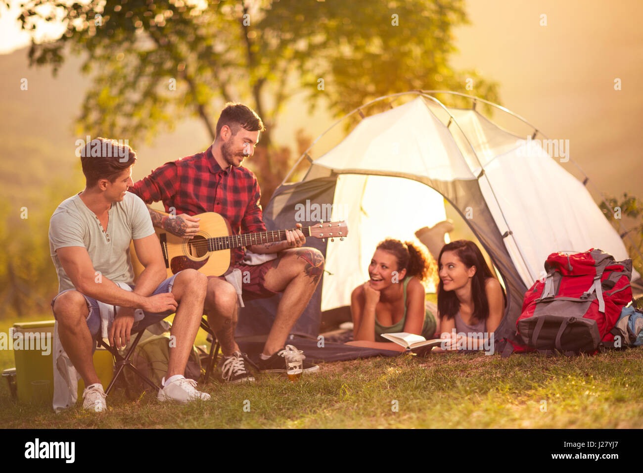 Romantische Zeit auf camping zwei Männer singen Mädchen im Zelt Stockfoto