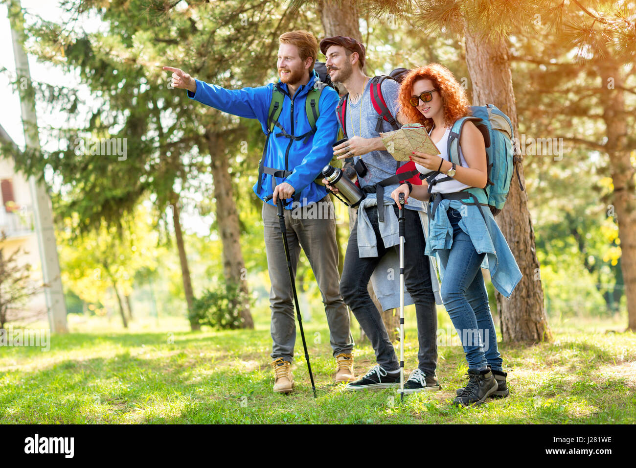 Jungen Führer der Wanderer-Gruppe zeigen mit Finger Weg in grünen Wald Stockfoto