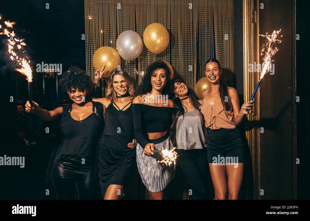 Schuss Gruppe von Girls feiern Silvester in der Diskothek. Gruppe von Freundinnen Party im Pub mit Wunderkerzen. Stockfoto