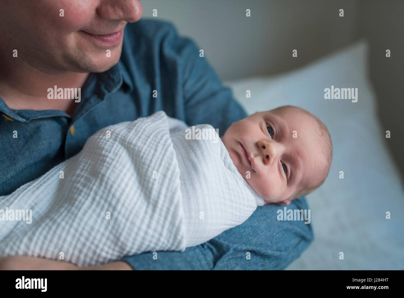 Porträt von niedlichen Neugeborenen Baby Boy von Vater zu Hause durchgeführt werden Stockfoto