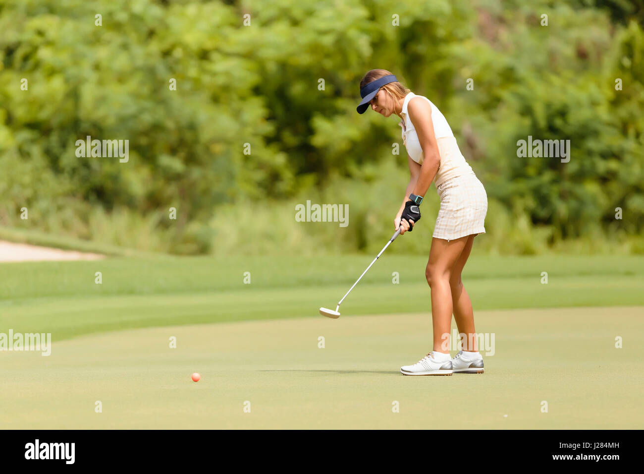 Seitenansicht der Frau Golfspielen am Golfplatz Stockfoto