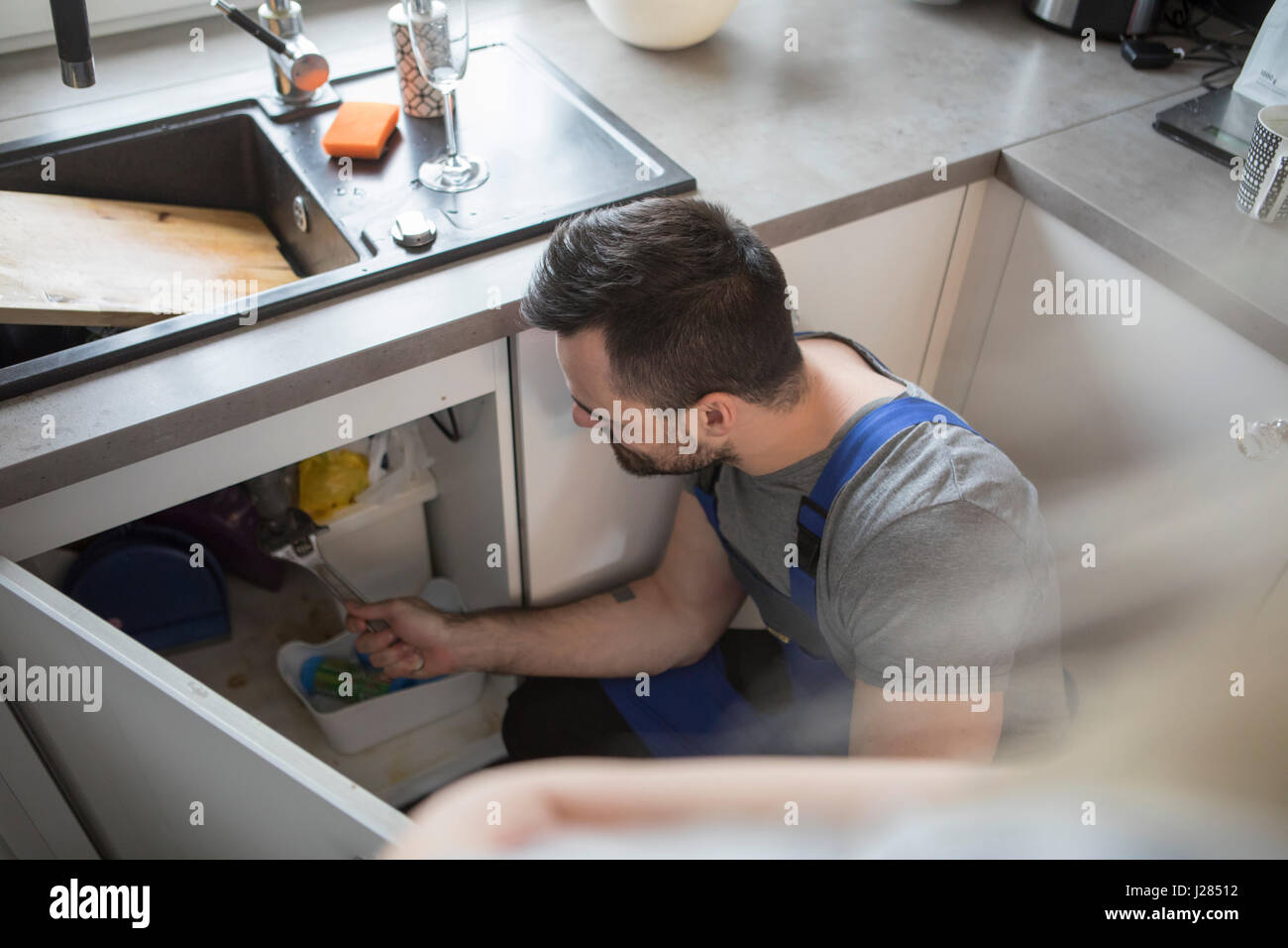 Erhöhte Ansicht des Menschen anpassen Rohr in Küche Stockfoto