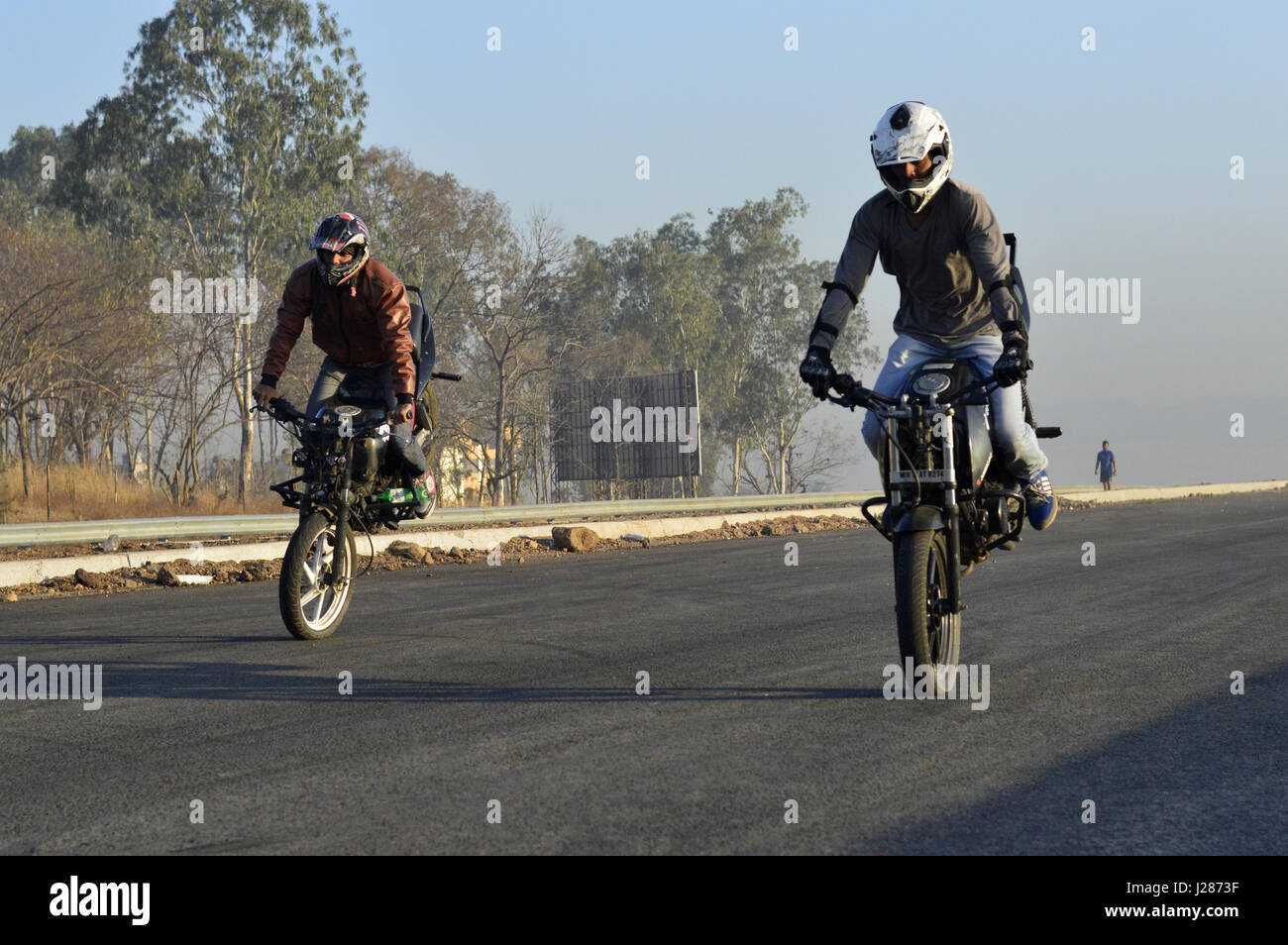 Zwei stunt Motorradfahrer Stoppie nahe Pune, Maharashtra Stockfoto