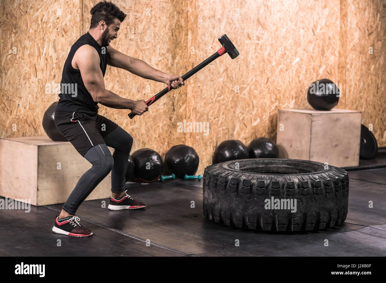 Sport Fitness Mann schlagen Rad Reifen mit Hammer Schlitten Crossfit  Training, gesunde junge Kerl Gym Interieur Stockfotografie - Alamy