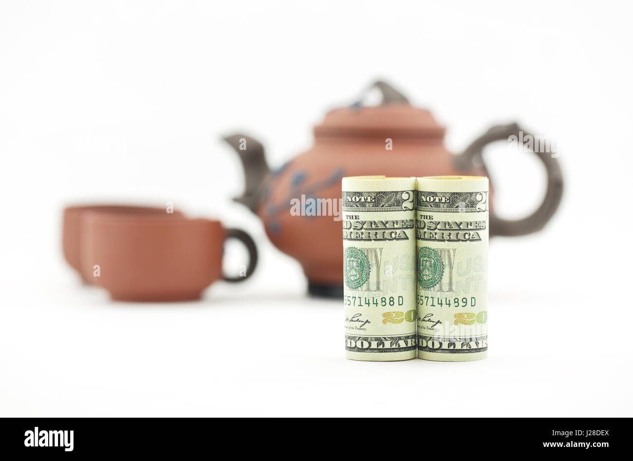 Zeit für Tee und geschäftliche Entscheidung nehmen.  Amerikanische Dollar-Währung mit Teekanne und zwei Tassen im Hintergrund. Konzeptionelle Symbole für Reflexion und co Stockfoto