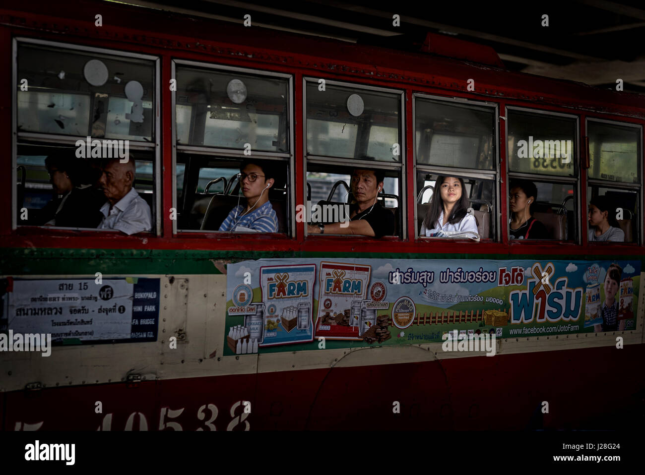 Frau in einem Bus, gefangen in einem Lichtschacht, aus dem Fenster schauend. Bangkok öffentliche Verkehrsmittel Thailand, Stockfoto